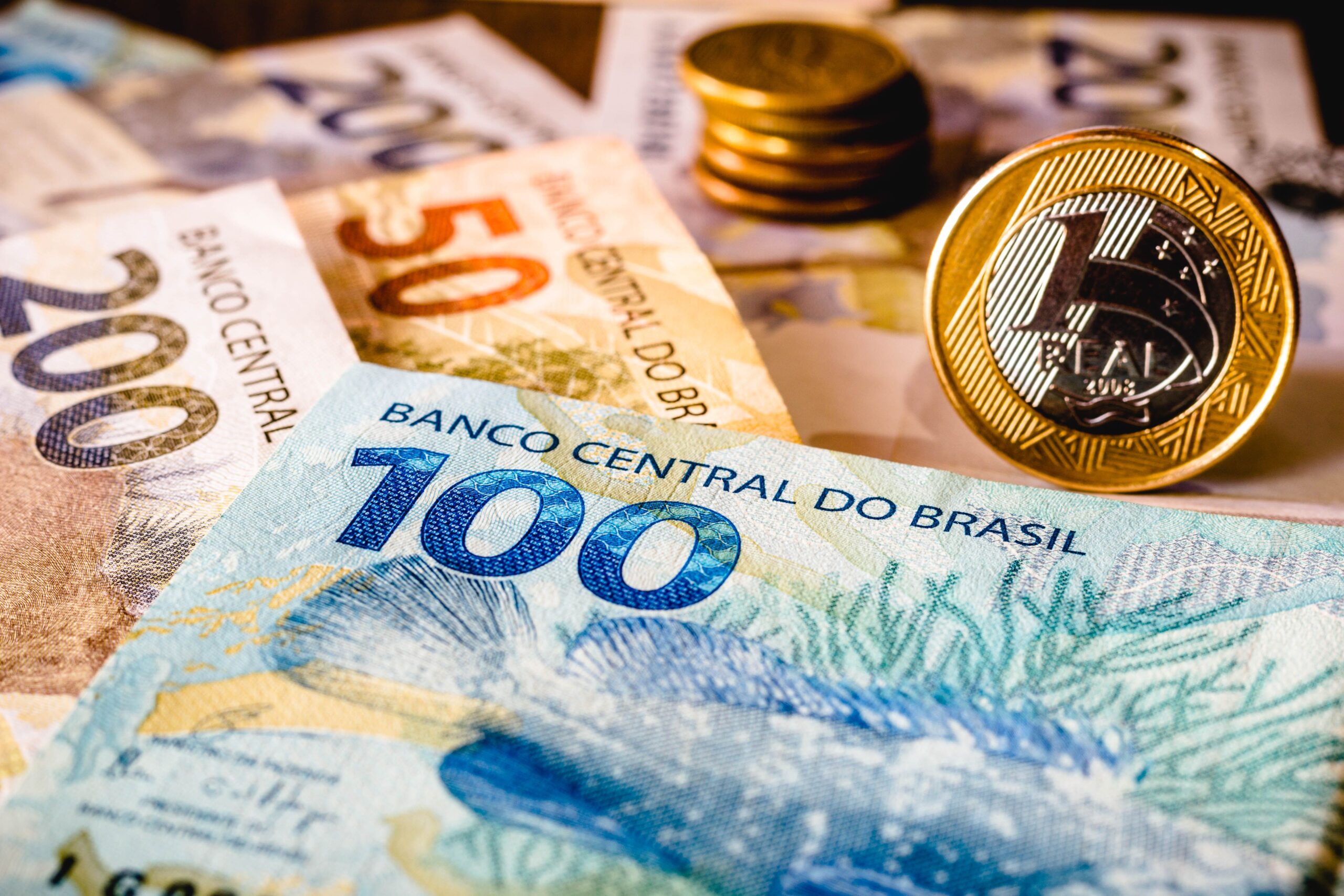nesta-foto-ilustracao-sendo-mostradas-notas-de-cinquenta-e-duzentos-reais-e-uma-moeda-de-um-real-em-destaque-o-real-e-o-dinheiro-atual-no-brasil_compressed
