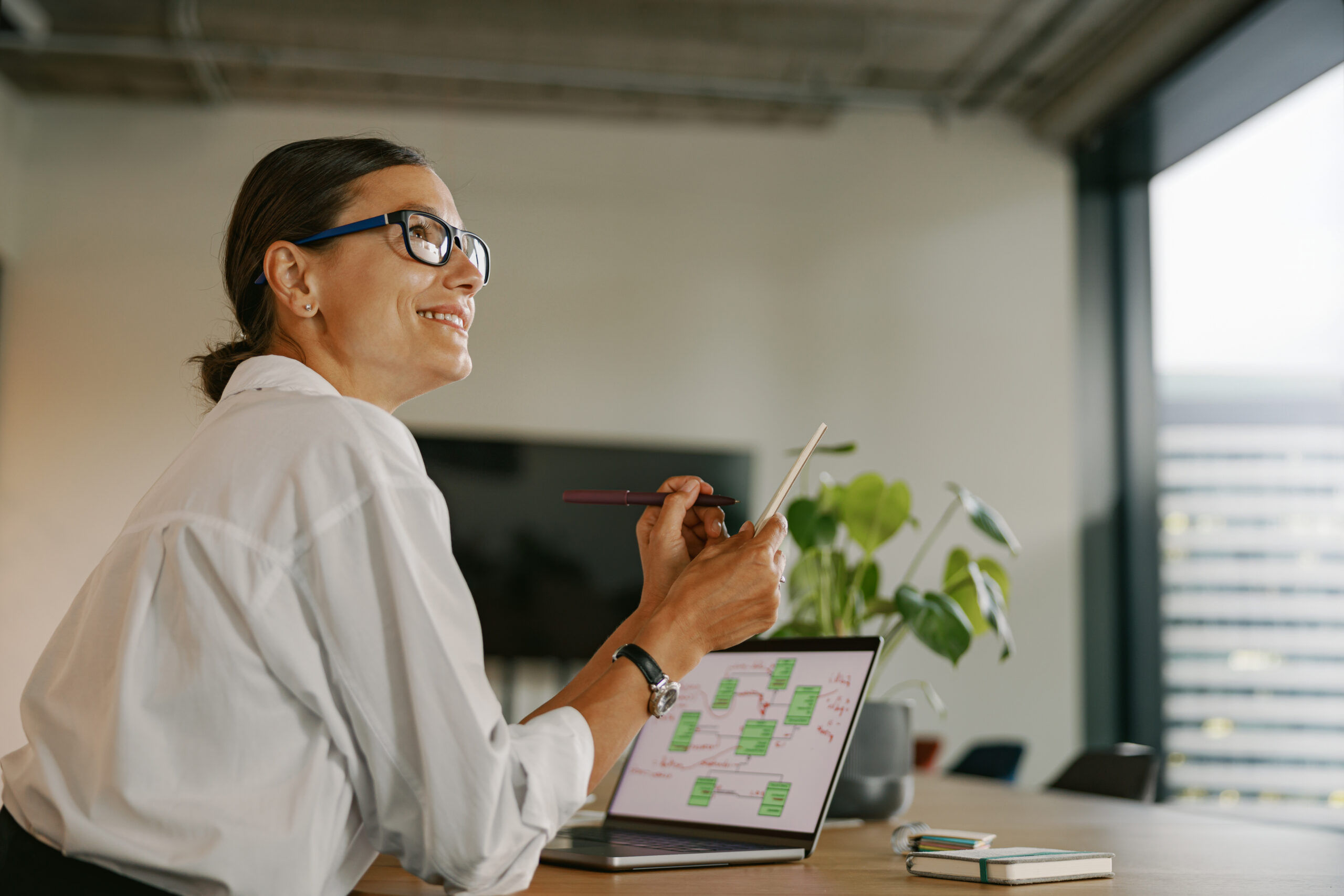 A Professional Woman Working in a Modern Office Environment While Engaging with Her Laptop A Professional Woman Working in a Modern Office Environment While Engaging with Her Laptop
